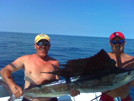 Two men holding a large sailfish.