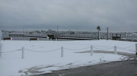 Snowy pier with a view of the bay.