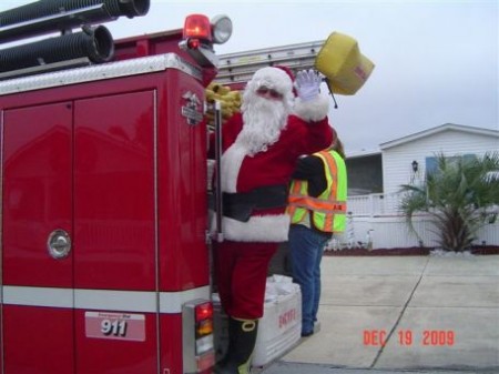 Santa Claus waves from a fire truck.