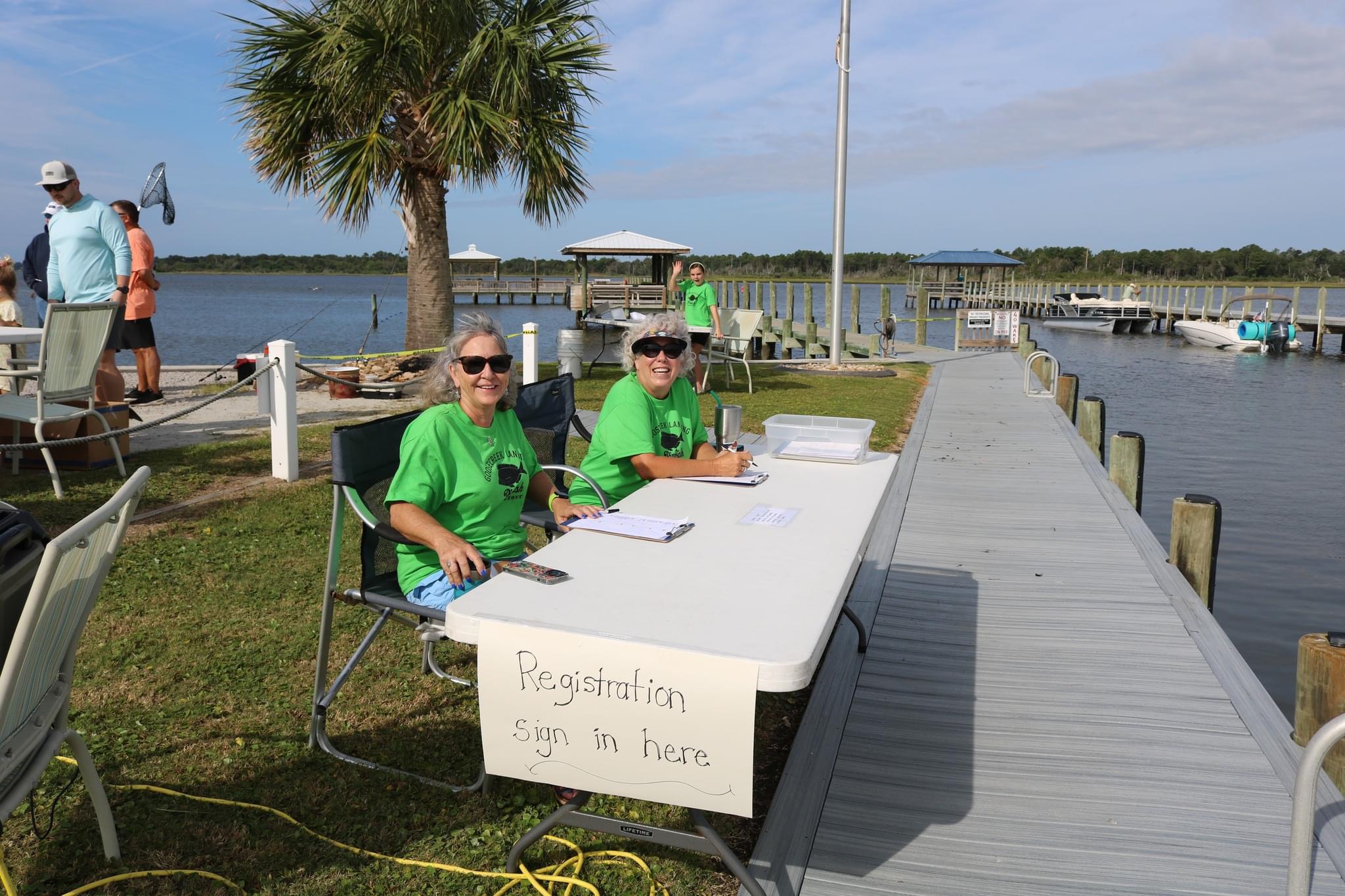 Two women at registration table by dock.