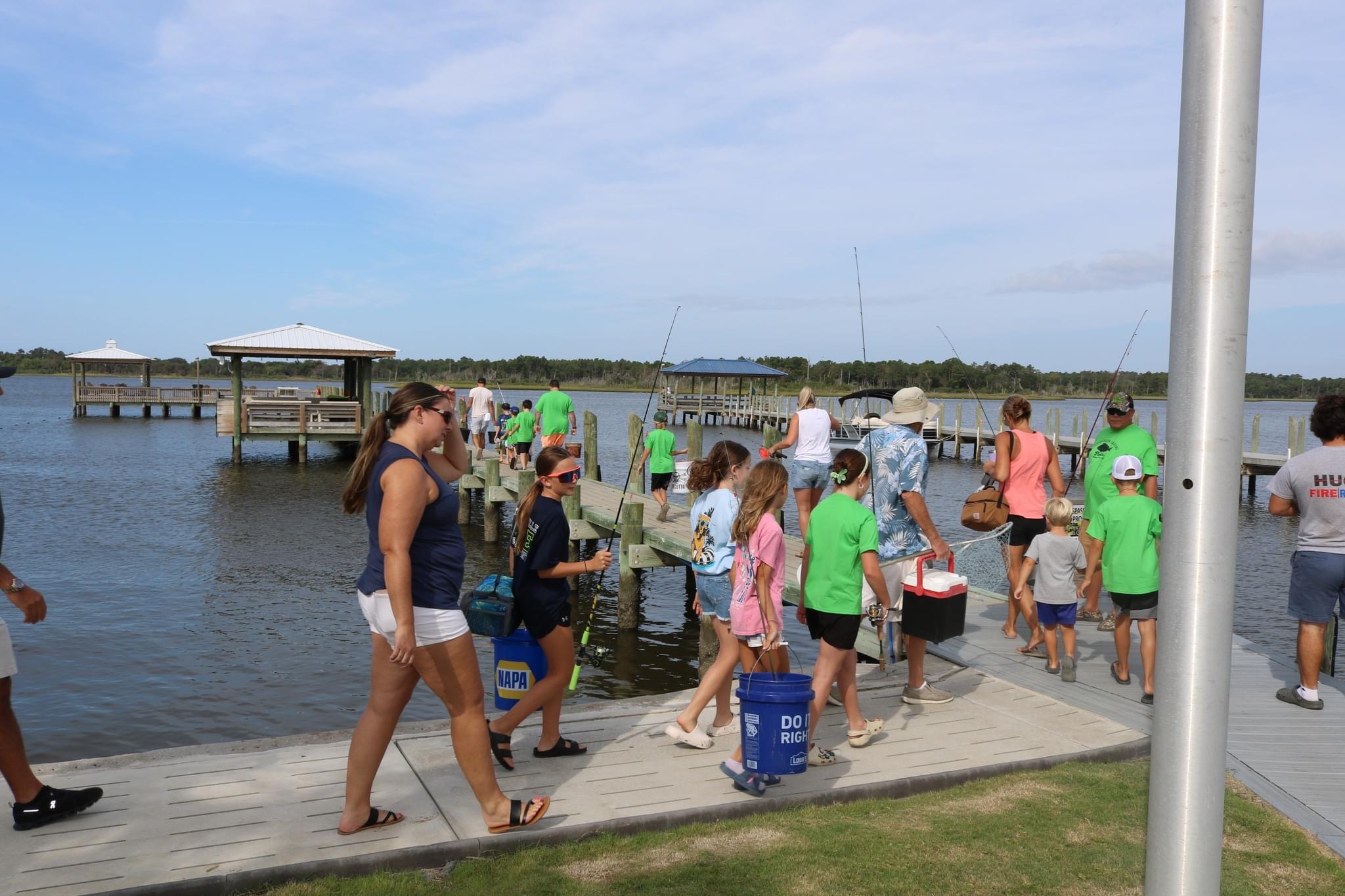 People fishing on a pier by the water.