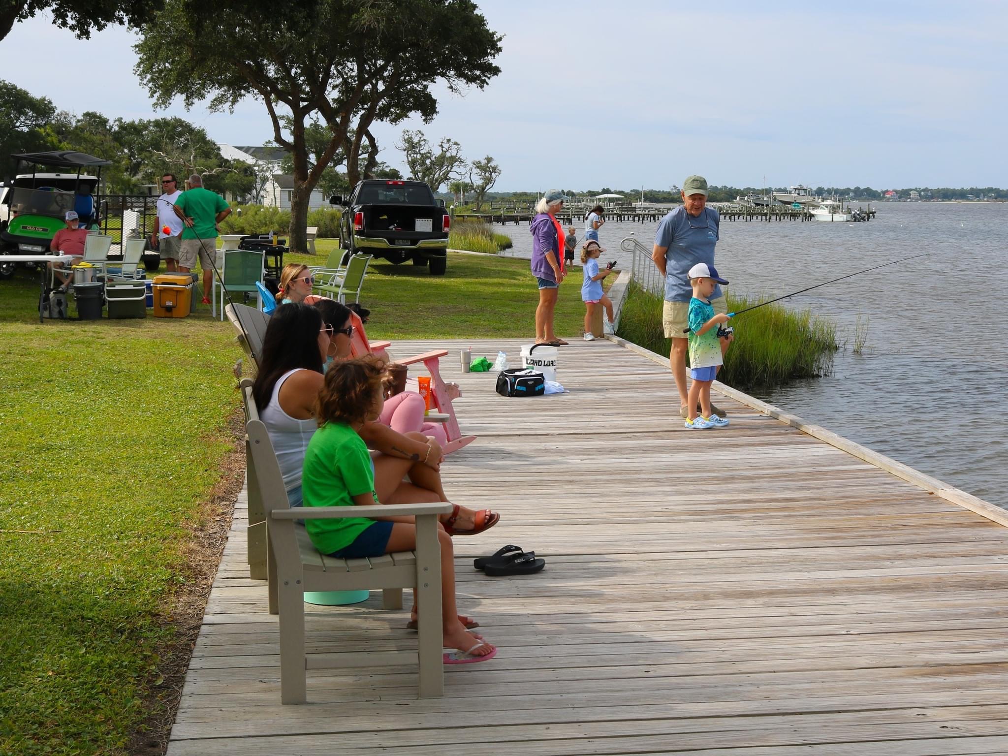 Family fishing on a wooden dock.