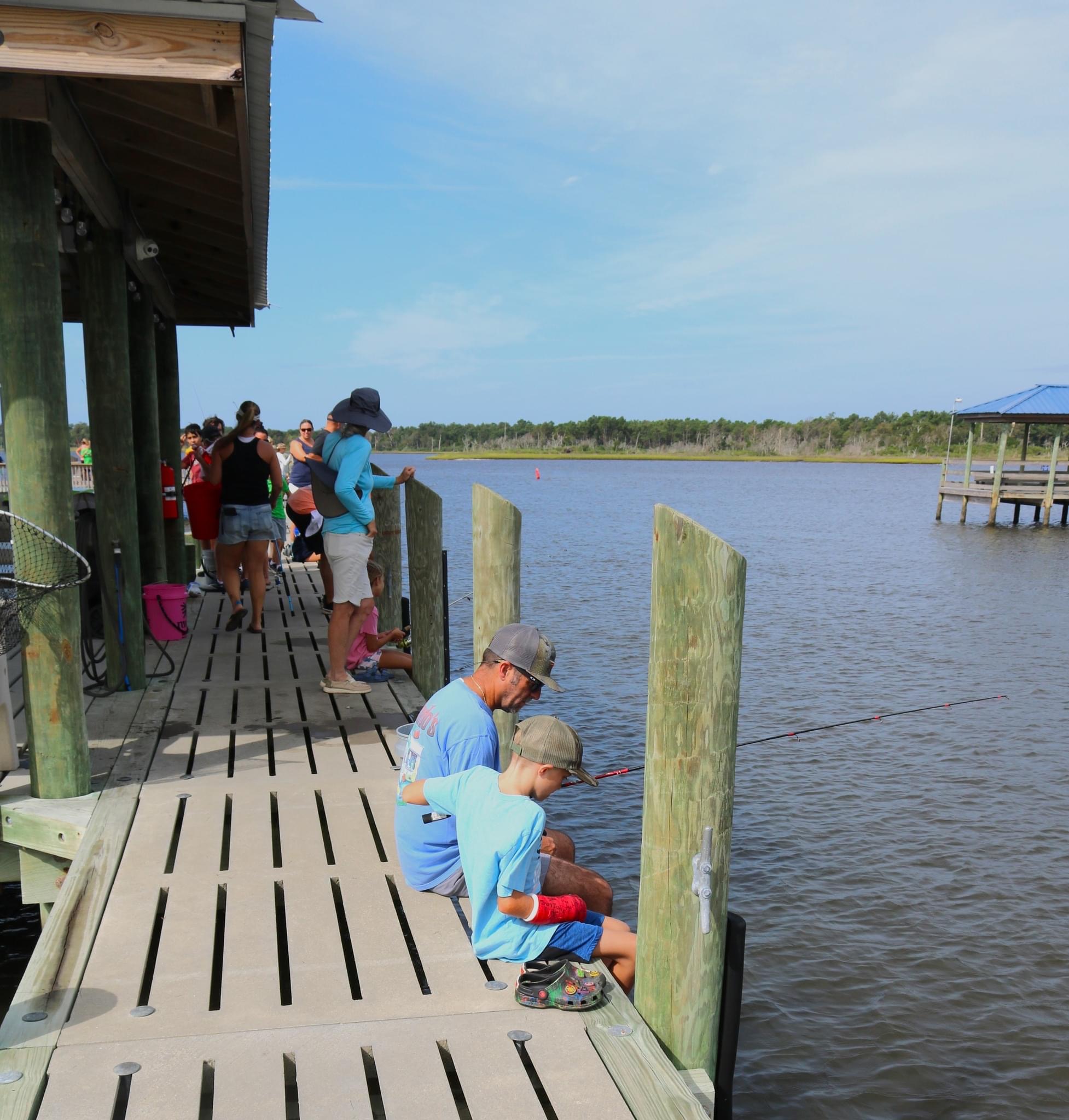 Father and son fishing on a dock.