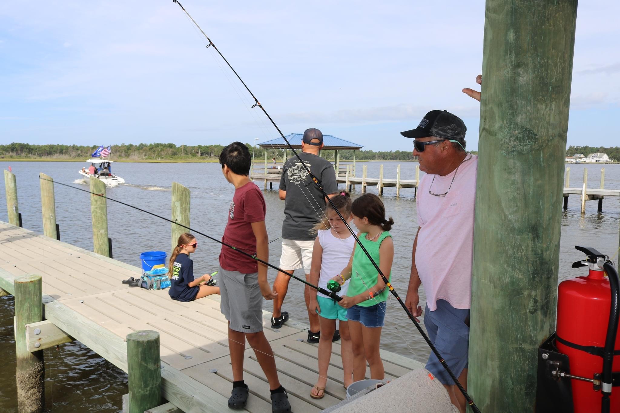 Family fishing on a wooden pier.