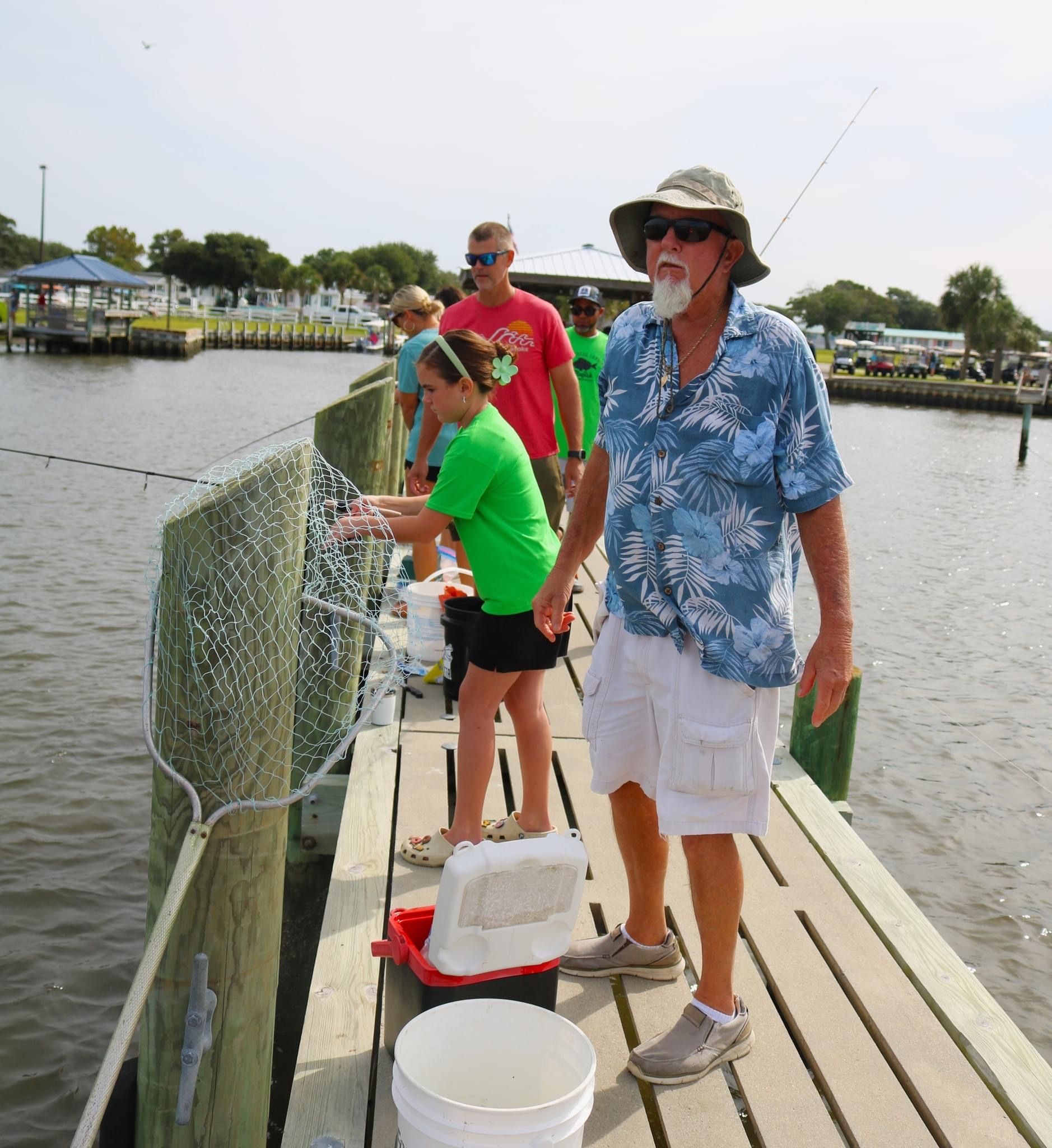 Group fishing on a wooden dock.