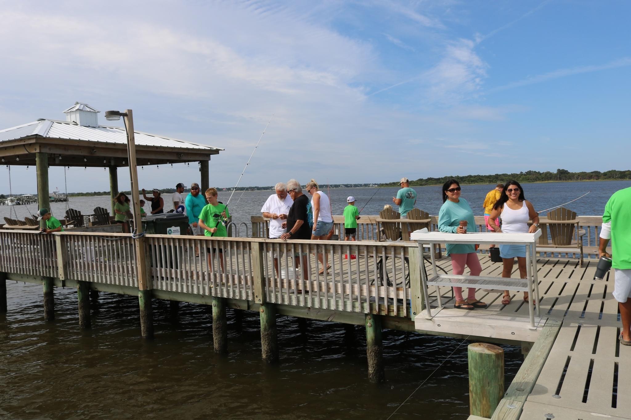 People fishing on a pier by the water.