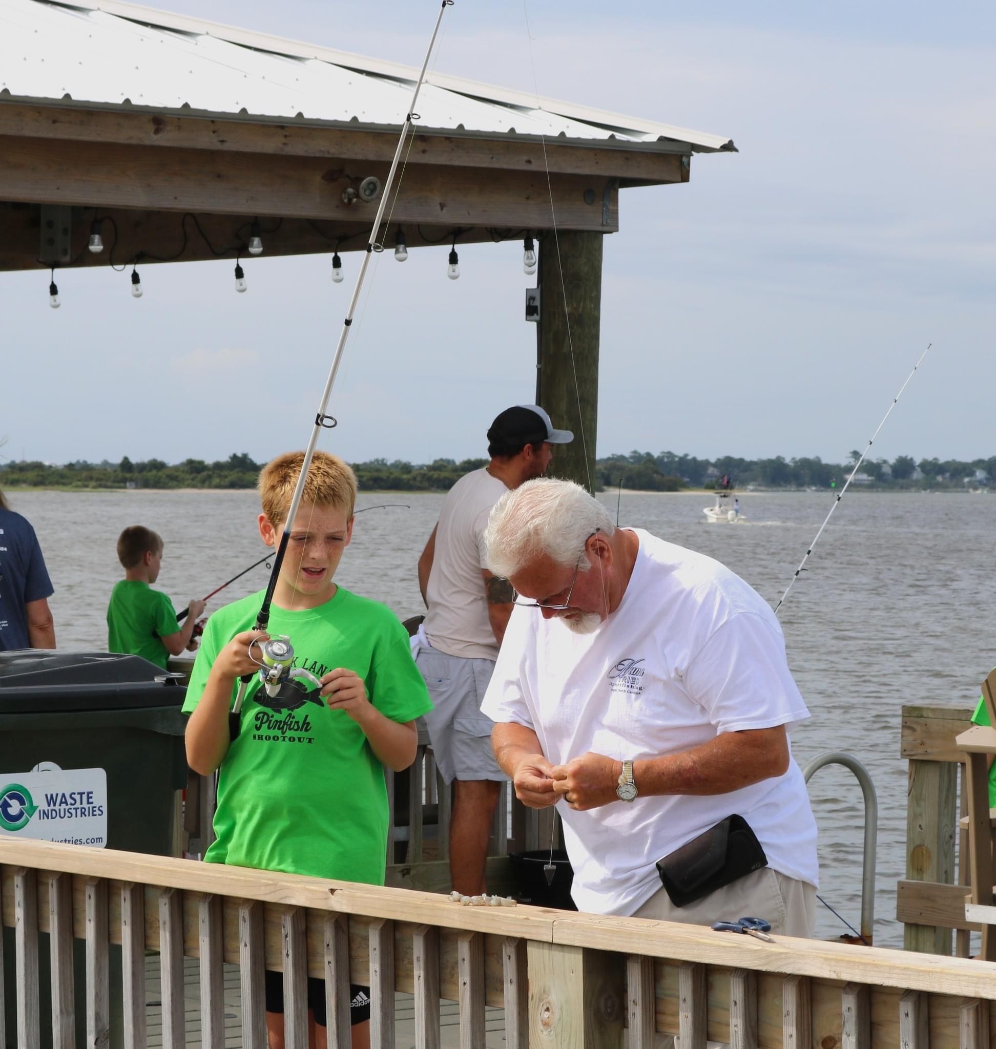 Three men fishing from a pier.