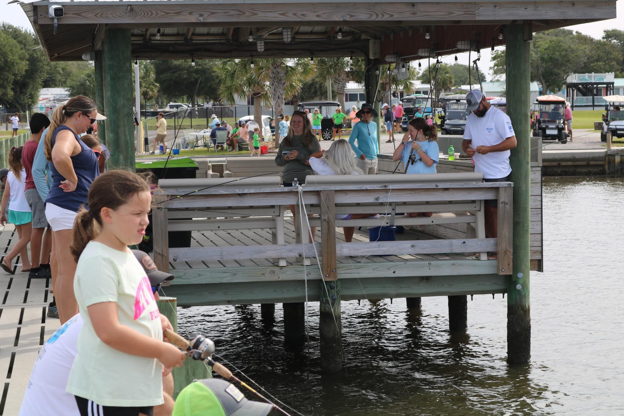 Family fishing on a pier by the water.
