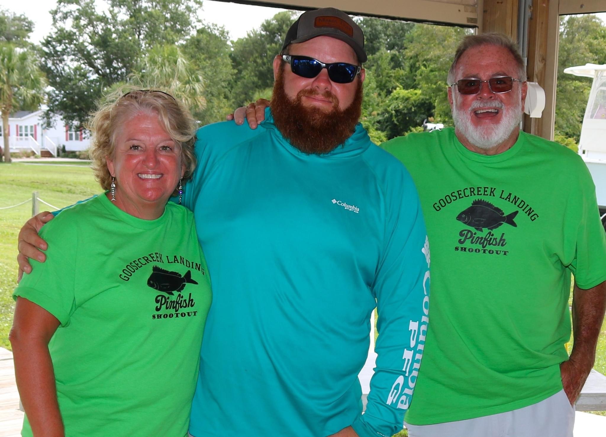 Three people wearing Goose Creek Landing shirts.